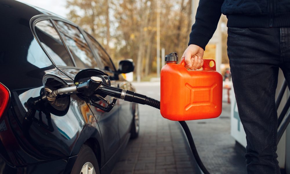 Man holding canister on gas station, fuel filling
