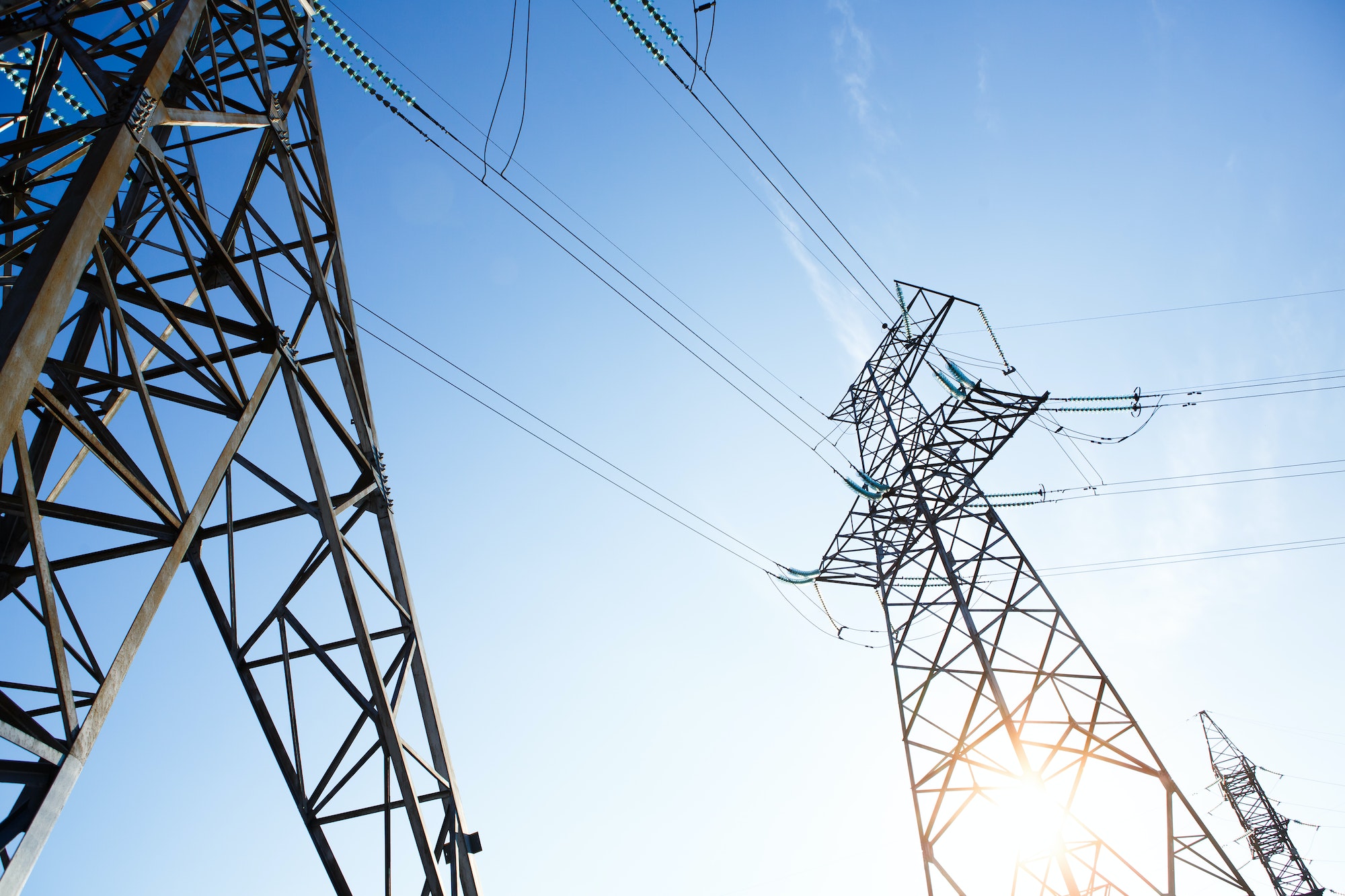 Electrical Grid and Transmission Line at Dusk. Electricity Pylons Against Sky at Sunset