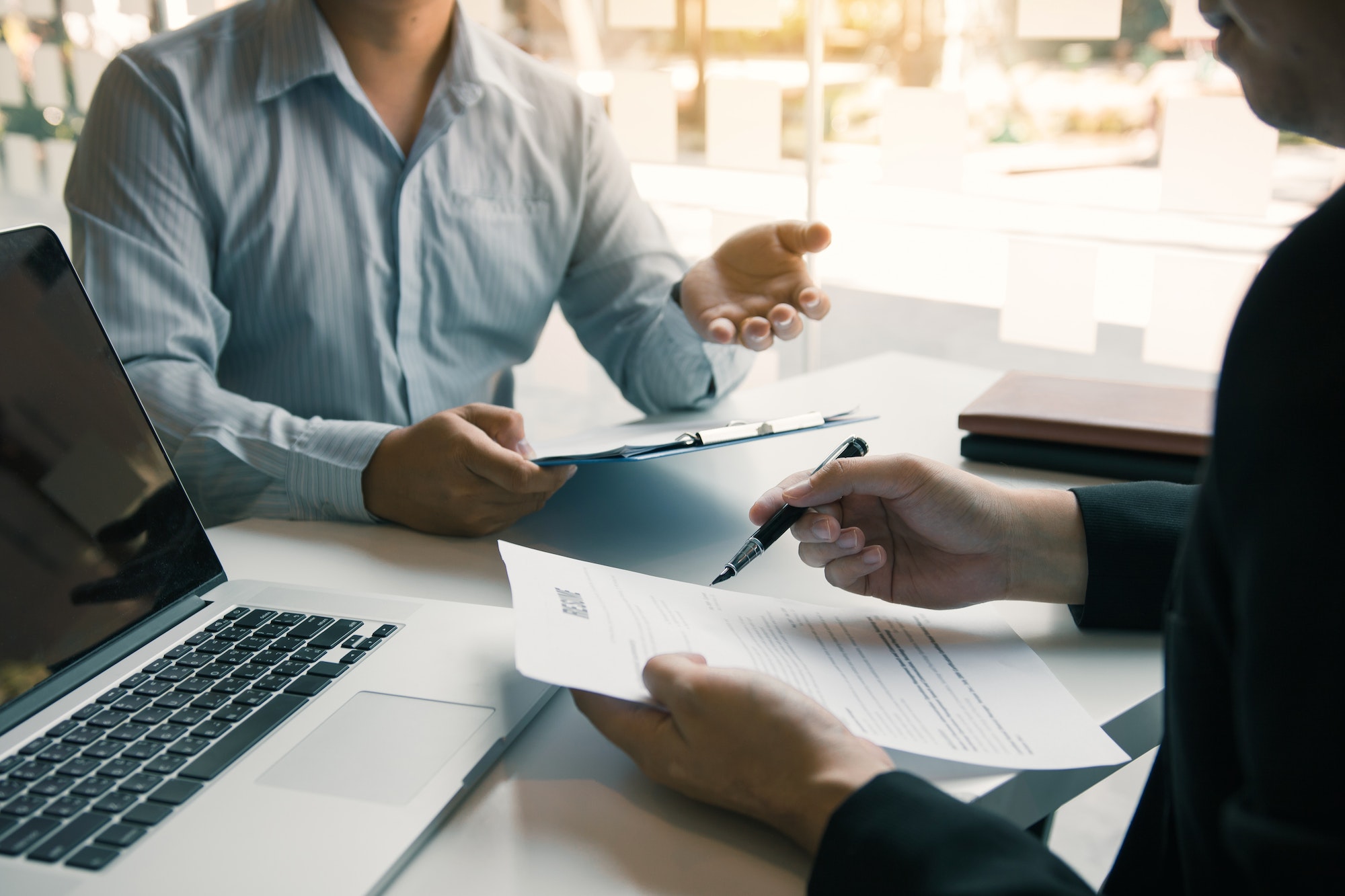 Job applicants are holding a resume document in the job interview room, job interview concept.